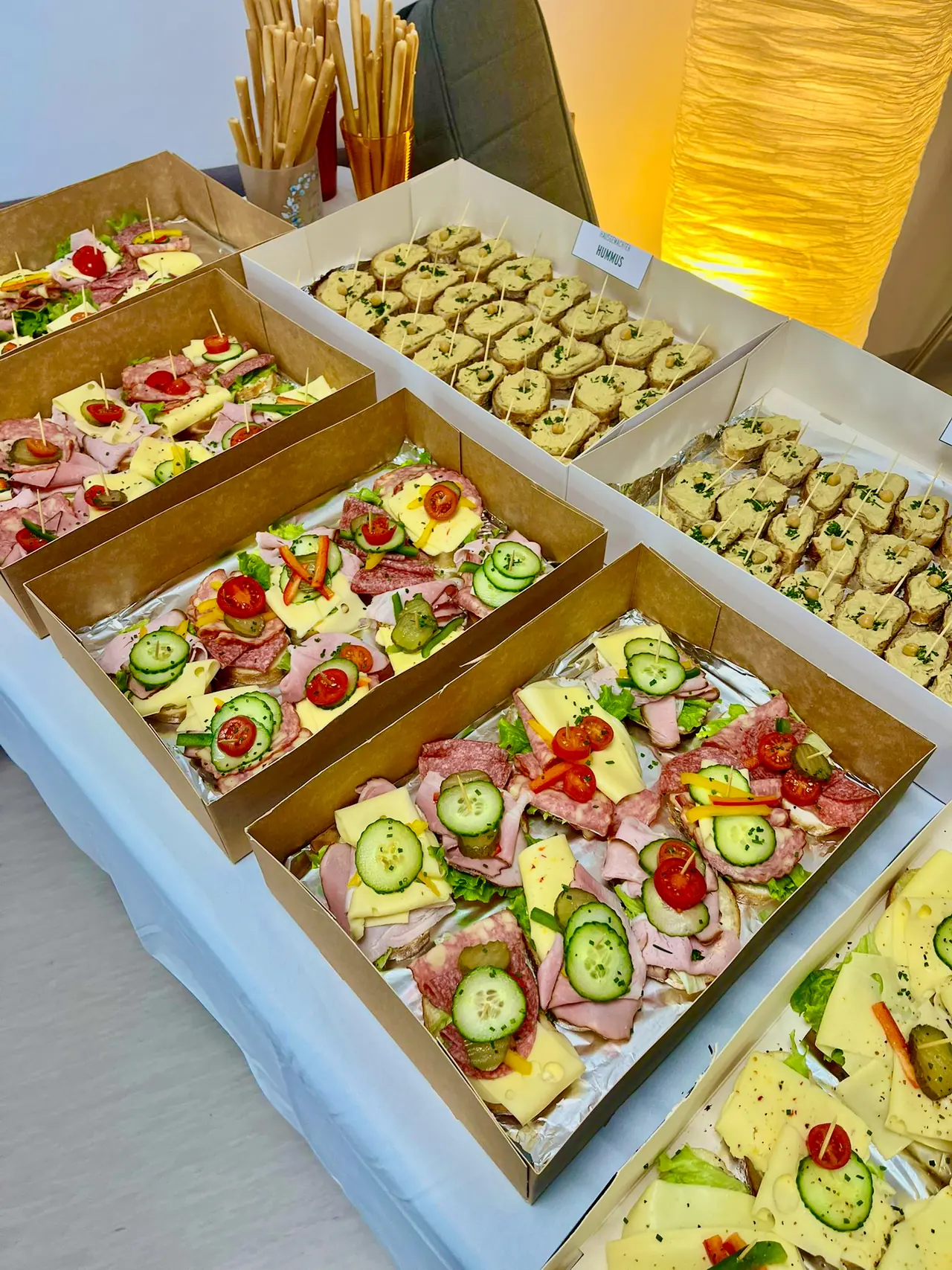 Mehrere Platten mit belegten Brötchen auf einem Buffettisch