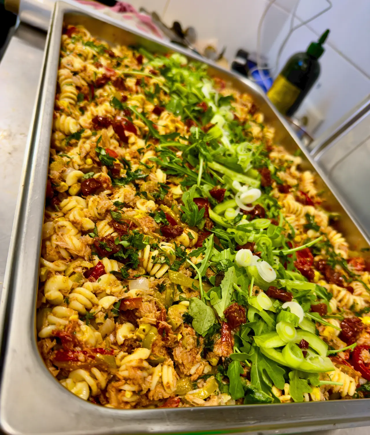 Große Wanne mit warmen Nudeln, Rucola und Gemüse